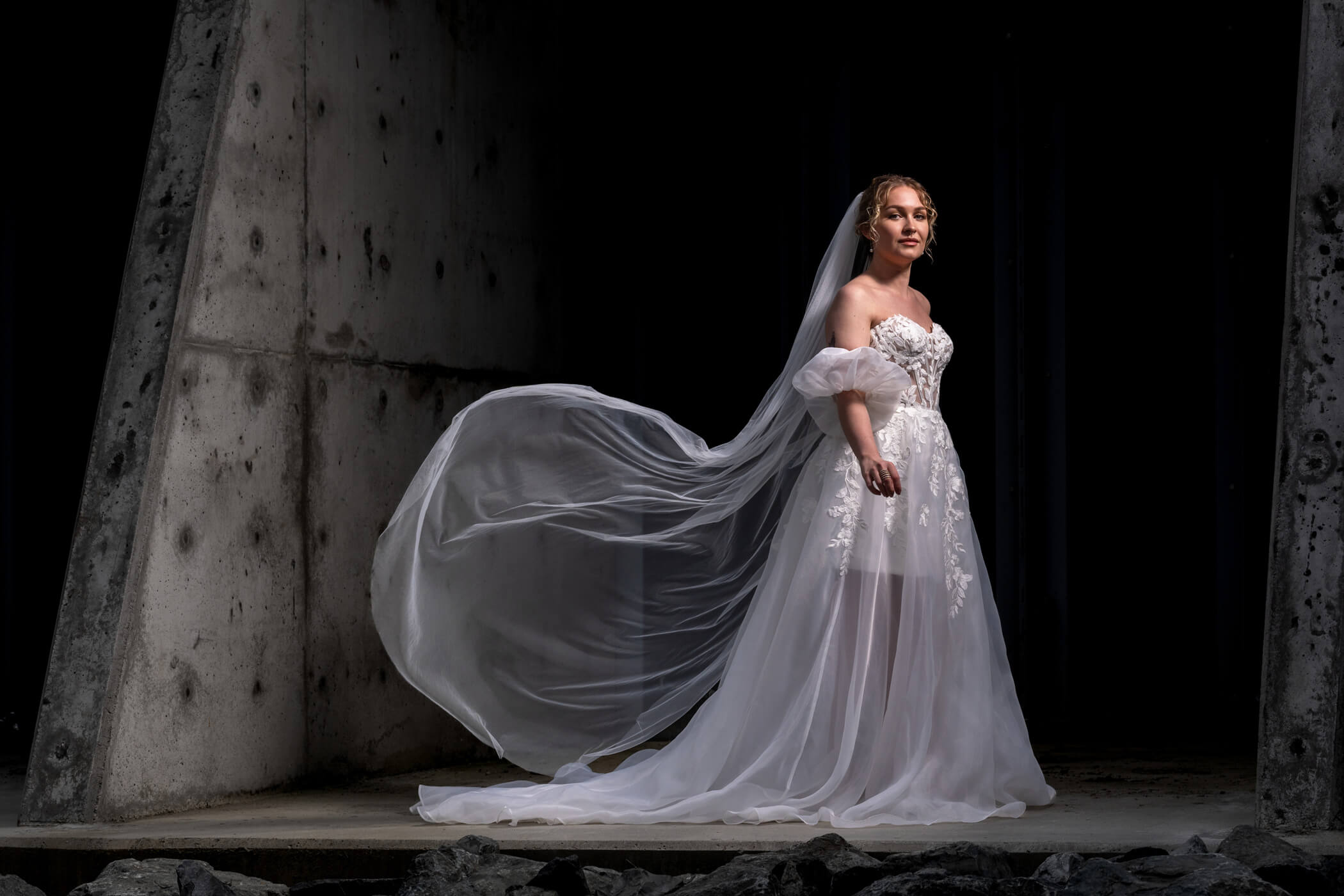 bride wearing a wedding dress from Stilly Lilly Bridal, Stanwood, Washington, posing at a tide gate