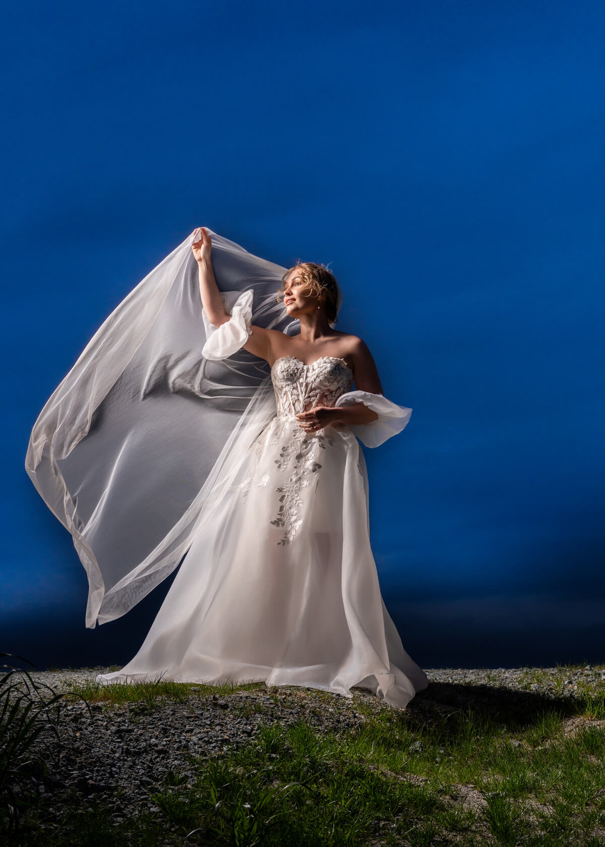 bride wearing a wedding dress from Stilly Lilly Bridal, Stanwood, Washington, on a levee at blue hour