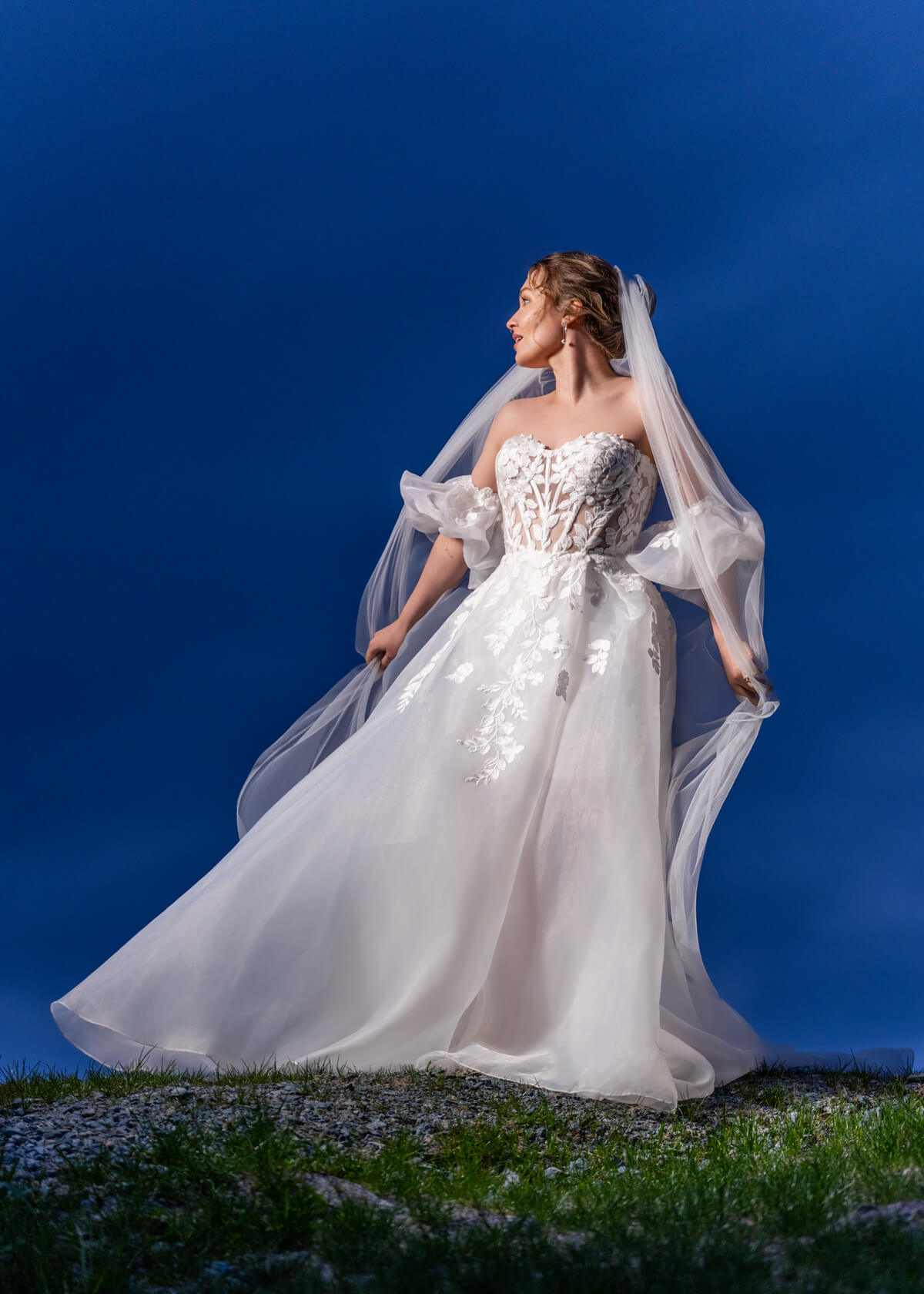 bride wearing a wedding dress from Stilly Lilly Bridal, Stanwood, Washington, on a levee at blue hour